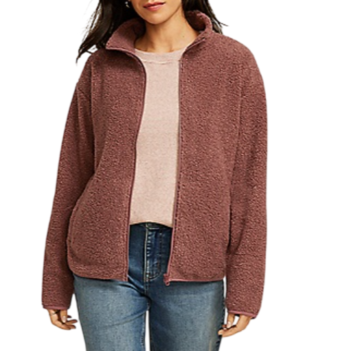 A woman wearing a mauve, zip-up fleece jacket with a high collar, styled over a pink top and blue jeans.