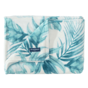 A Tommy Bahama beach-themed throw with a tropical leaf design in shades of teal and white. The plush fabric features a soft texture, ideal for cozy settings.