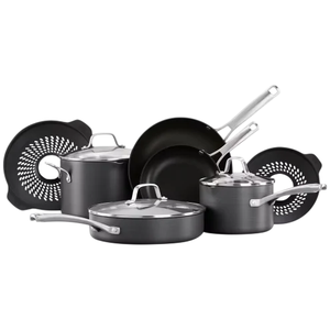 A cookware set including saucepans, skillets, and pots with lids, made of dark material with metallic handles, accompanied by two circular silicone trivets.