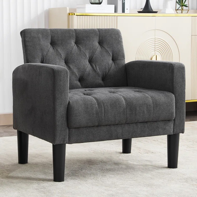 A dark gray upholstered armchair with a tufted back and seat, featuring straight armrests and four black wooden legs.