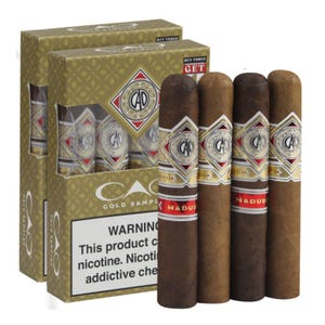 Eight CAO cigars are displayed alongside their packaging, which features a gold and green design with a prominent CAO logo; a warning about nicotine is visible on the box.