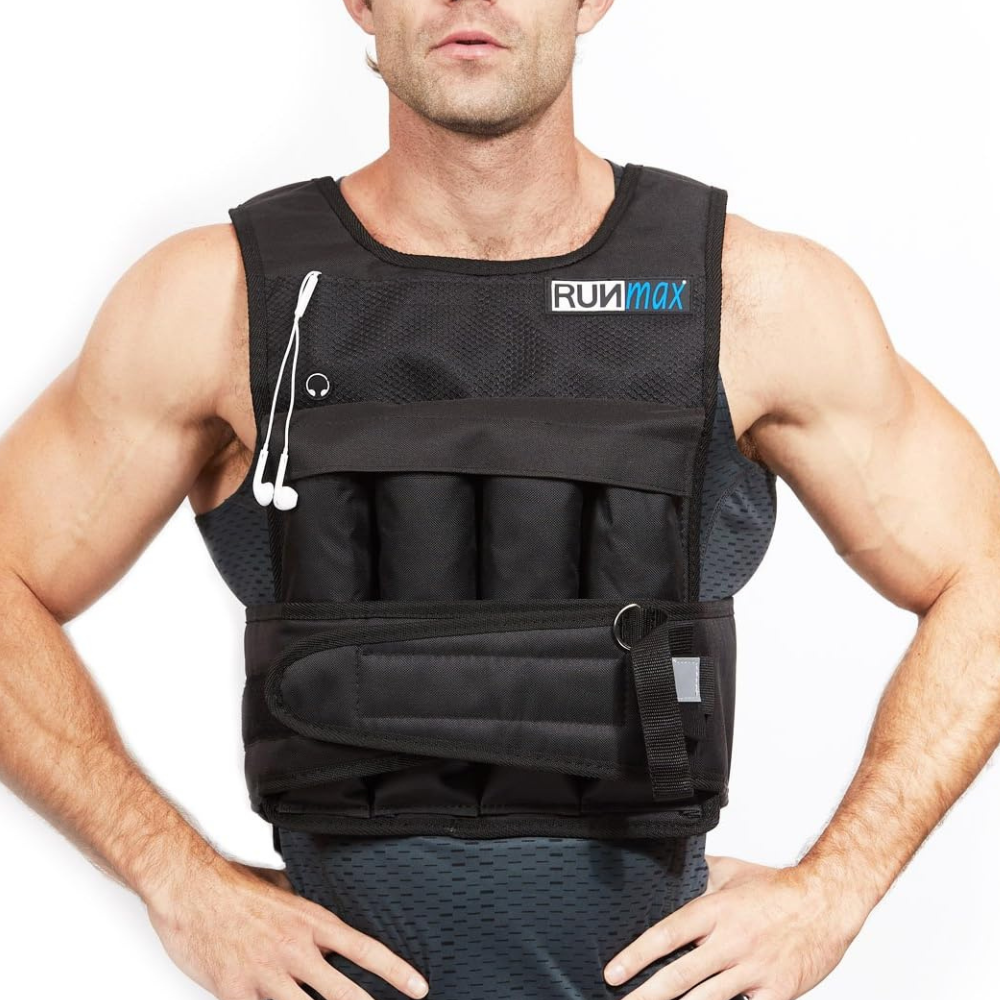 A person is wearing a black weighted vest from RUNmax, which has pockets and an attached strap. Earbuds are hanging from the front.