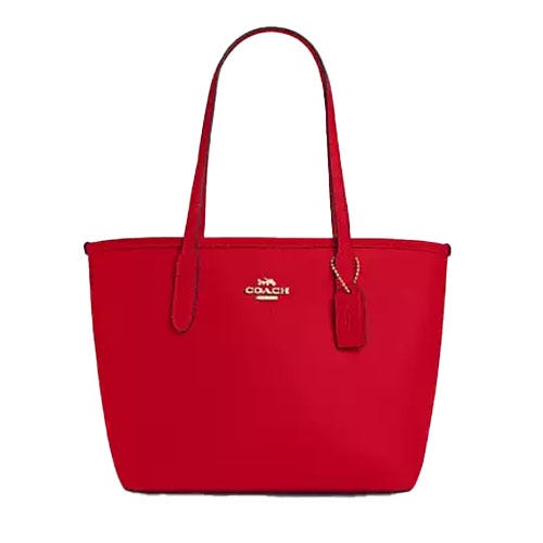 Red leather Coach Outlet tote with gold logo and detailing, two handles, and a hanging tag.