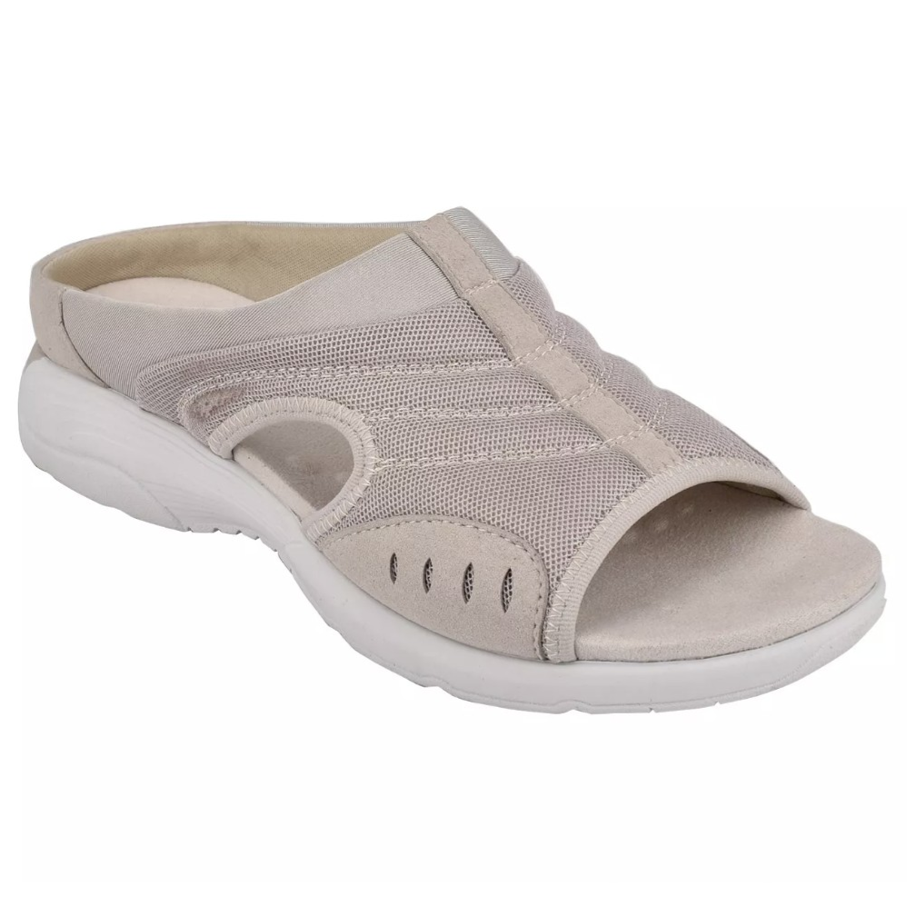 A beige slip-on sandal with mesh and suede detailing, featuring a peep-toe design and white cushioned sole for comfort.