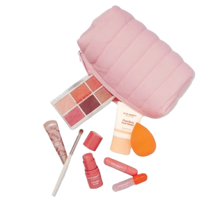 A makeup set with pink cosmetics bag, eyeshadow palette, sponge, lip gloss, nail polish, and a brush.