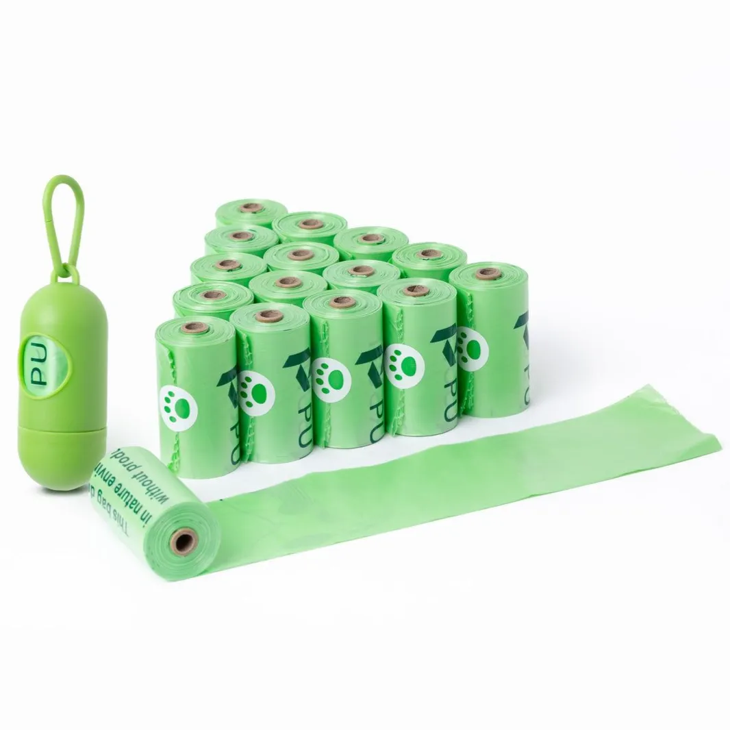 A set of green pet waste bags in rolls, featuring a small paw print design and a coordinating green capsule-shaped holder with a hook for easy attachment.