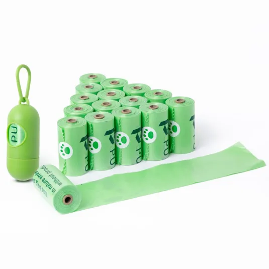 A set of green pet waste bags in rolls, featuring a small paw print design and a coordinating green capsule-shaped holder with a hook for easy attachment.