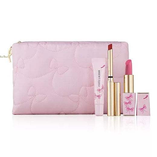 A pink makeup pouch with a bow design containing an Estée Lauder lip gloss, a thin tube of lipstick, and a traditional lipstick, all adorned with pink ribbon and bow motifs.