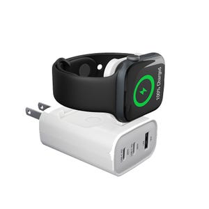 A smart watch with a black band is charging on a compact wall charger that includes multiple USB ports, including USB-C and USB-A.