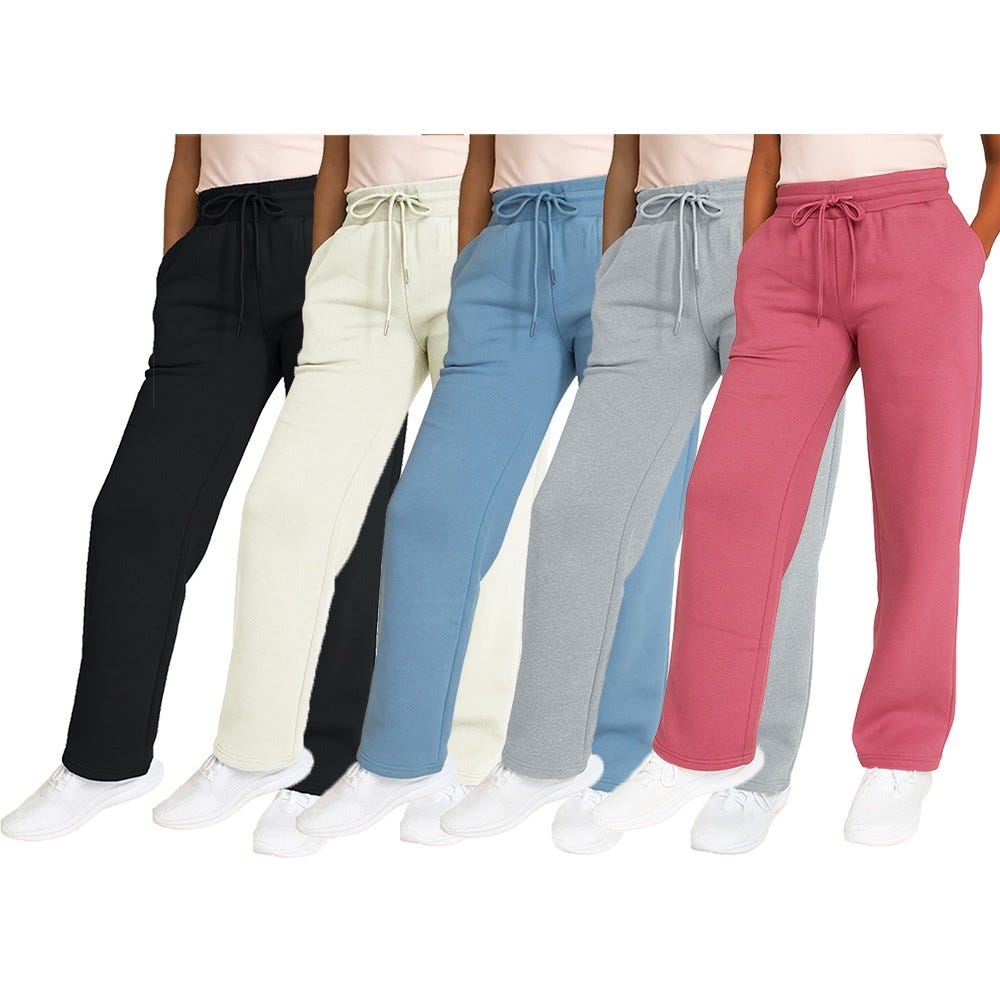 Five pairs of women's sweatpants in black, cream, blue, gray, and pink are displayed, each featuring an elastic waistband with a drawstring and paired with white sneakers.