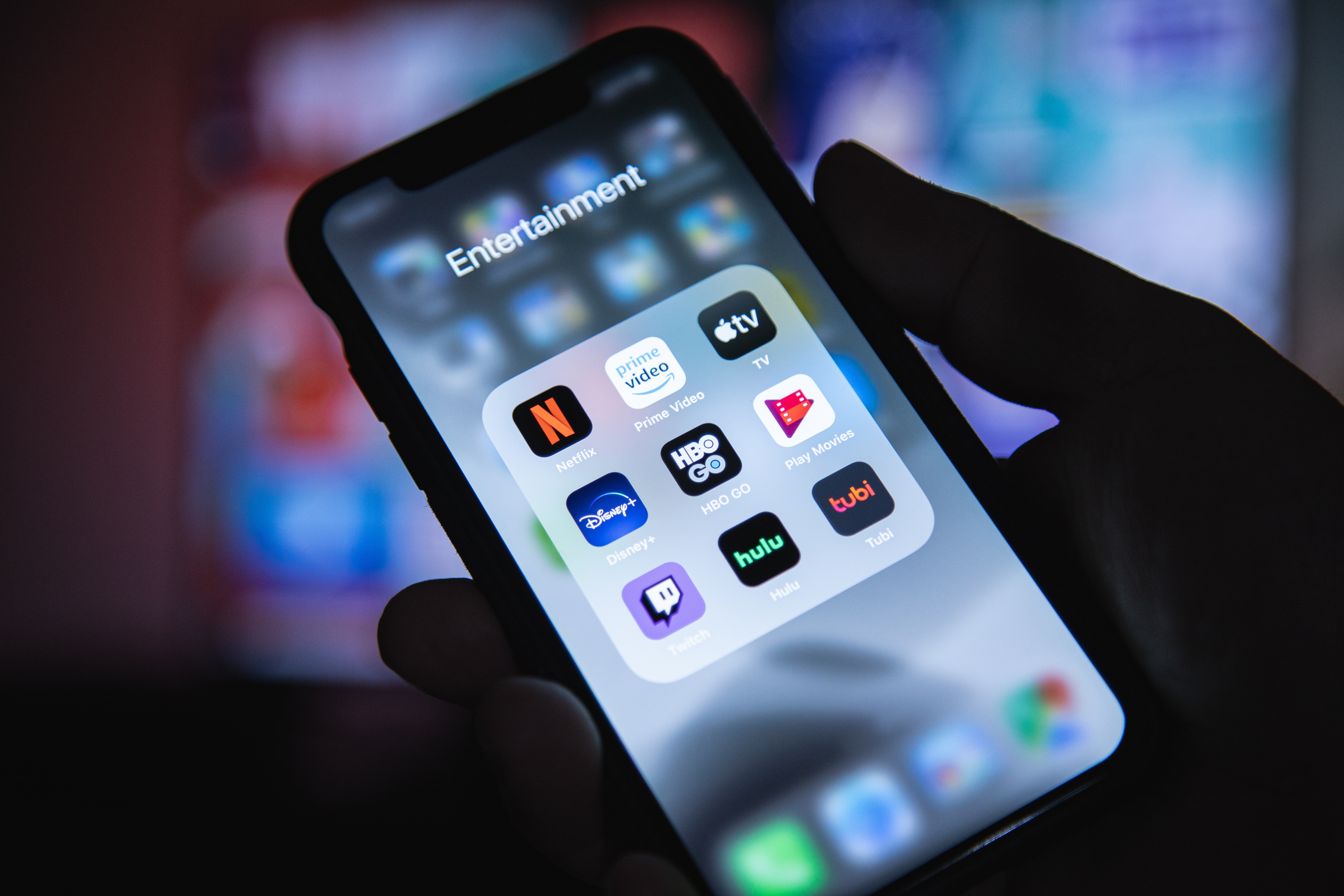 A smartphone screen displaying a folder labeled 'Entertainment' with app icons for various streaming services.