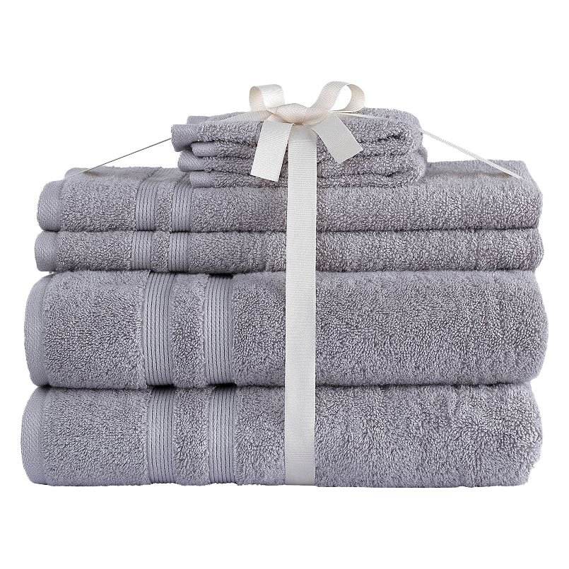 A set of neatly stacked gray towels tied with a white ribbon, featuring different sizes, including bath towels and washcloths.