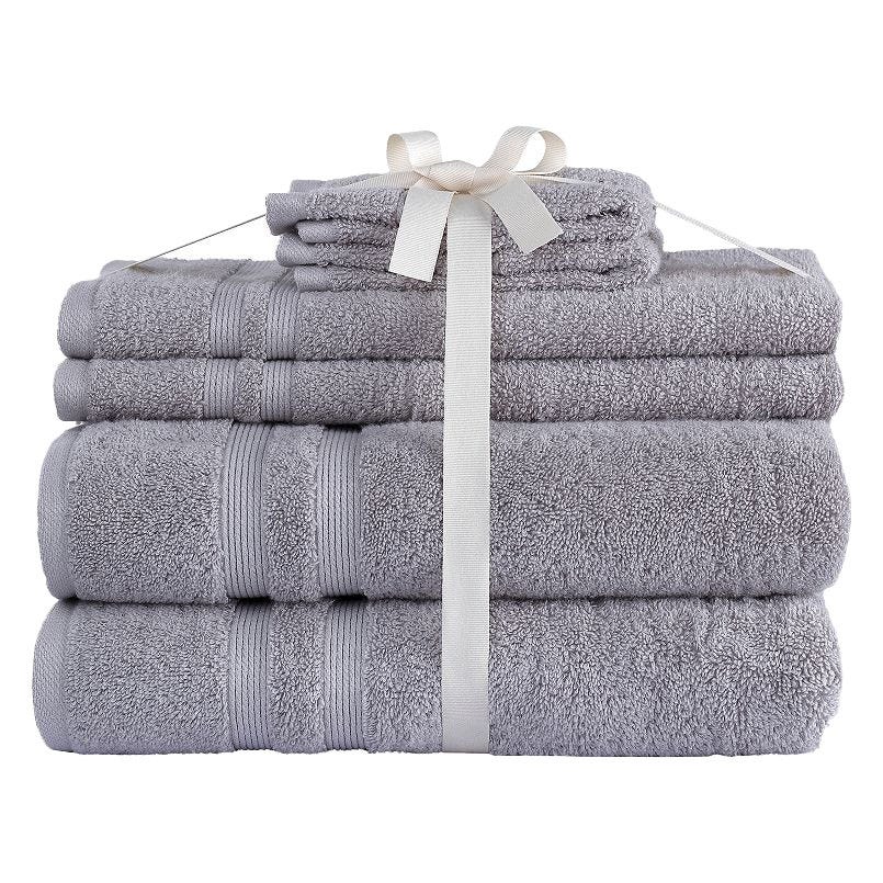 A set of neatly stacked gray towels tied with a white ribbon, featuring different sizes, including bath towels and washcloths.