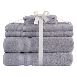 A set of neatly stacked gray towels tied with a white ribbon, featuring different sizes, including bath towels and washcloths.