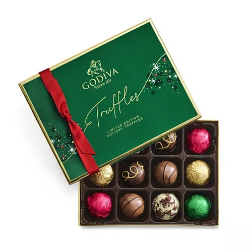 an open box of Godiva chocolate truffles with a green top