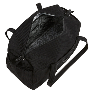 A black quilted bag with a spacious interior featuring a floral patterned lining, two handles, and a zippered opening.
