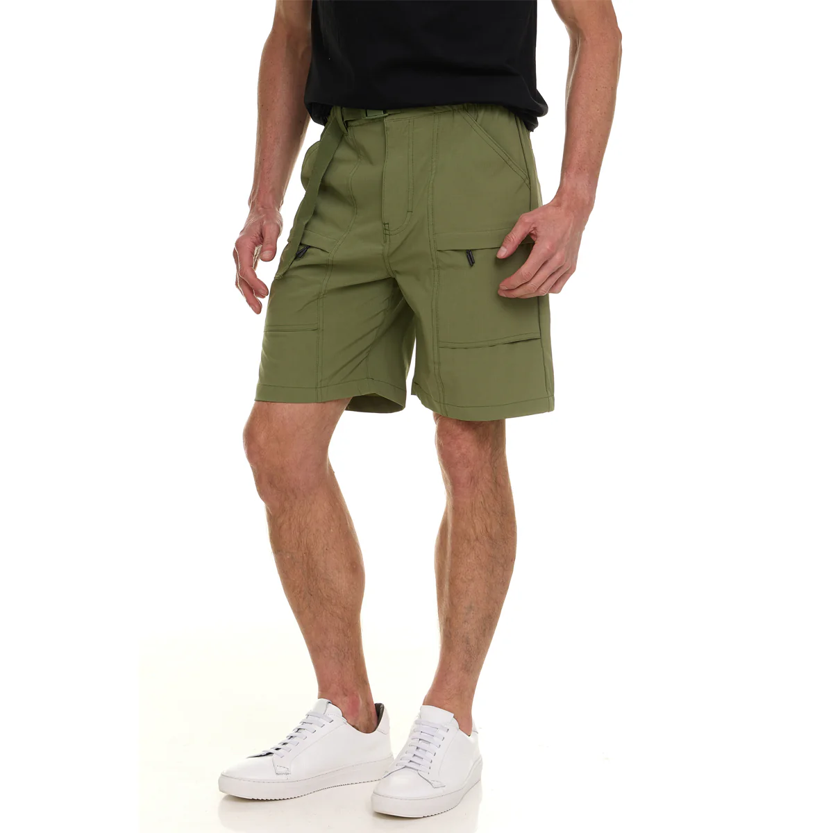 Green cargo shorts with multiple pockets, worn by a person in a black shirt and white sneakers.
