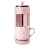 Pink Keurig coffee maker brewing coffee into a matching pink mug.