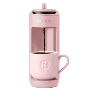 Pink Keurig coffee maker brewing coffee into a matching pink mug.