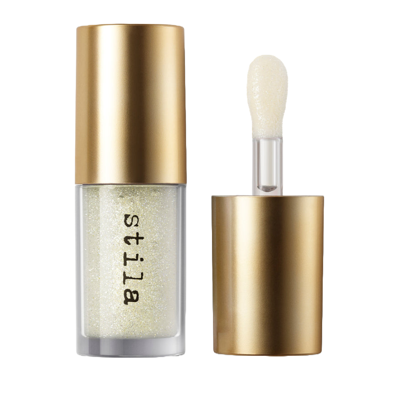 A clear lip oil from Stila in a small bottle with a glossy golden cap and a foam applicator wand. The formula appears to contain fine shimmer particles.