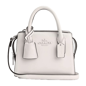 A white leather Coach Outlet Carryall handbag featuring dual top handles, a detachable shoulder strap, and signature Coach branding. It includes two hanging tags with a subtle, minimalist design.