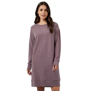 A woman wearing a long-sleeve, knee-length, mauve sweater dress with a round neckline.