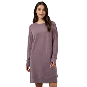 A woman wearing a long-sleeve, knee-length, mauve sweater dress with a round neckline.