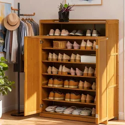 A wooden shoe cabinet with open doors displays multiple rows of shoes. It has a planter on top, next to a coat rack holding hats and clothes, situated in a room with a potted plant.