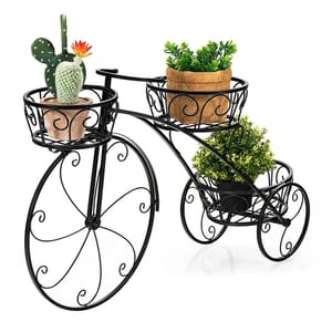 A black metal plant stand designed like a bicycle, featuring three spots for holding small potted plants, with decorative scrollwork on the wheels.