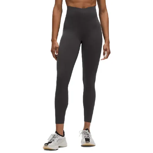 High-waisted, charcoal-gray leggings paired with white athletic sneakers.