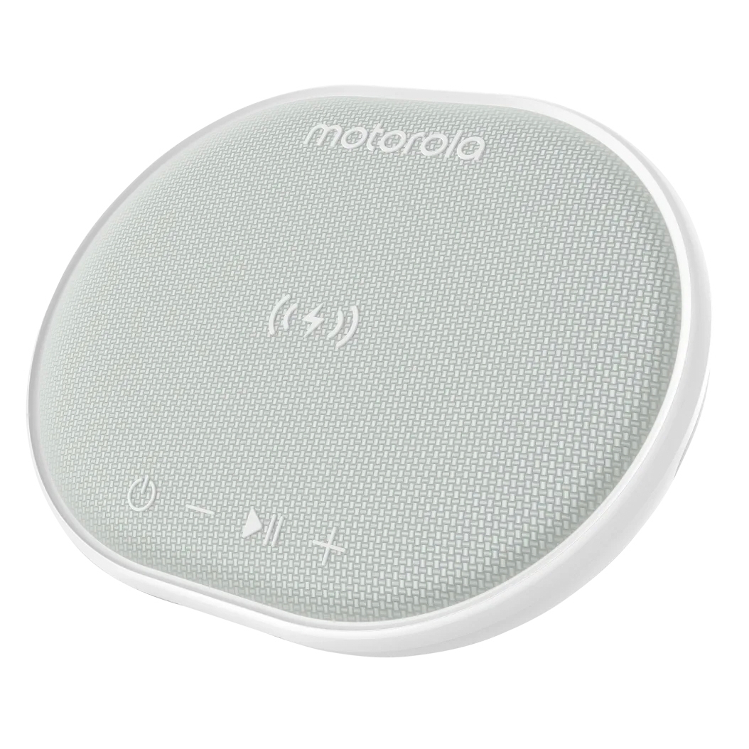 A circular Motorola device combining a wireless charging pad and Bluetooth speaker, with a fabric top featuring touch controls for power, volume, and play/pause, along with a charging icon.