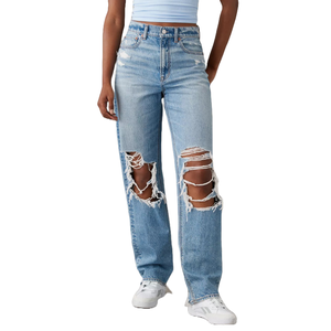 Light blue ripped baggy straight jeans with large distressed holes on both legs, high-waisted with a button and zip closure, paired with a light blue top and white sneakers.