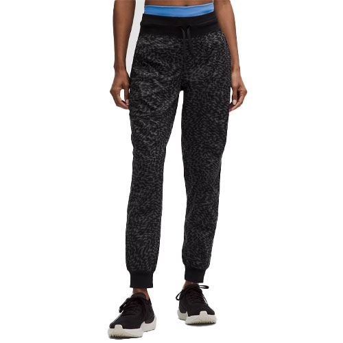 Textured black joggers with a drawstring waistband, ribbed cuffs, and paired with black sneakers.