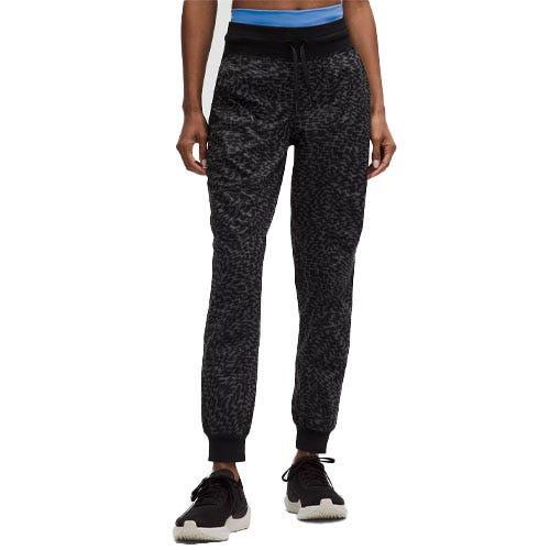 Textured black joggers with a drawstring waistband, ribbed cuffs, and paired with black sneakers.