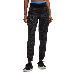 Textured black joggers with a drawstring waistband, ribbed cuffs, and paired with black sneakers.