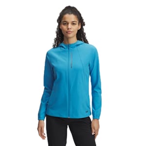 A woman is wearing a bright blue Under Armour full-zip hoodie with the brand's logo near the zipper, paired with black pants.