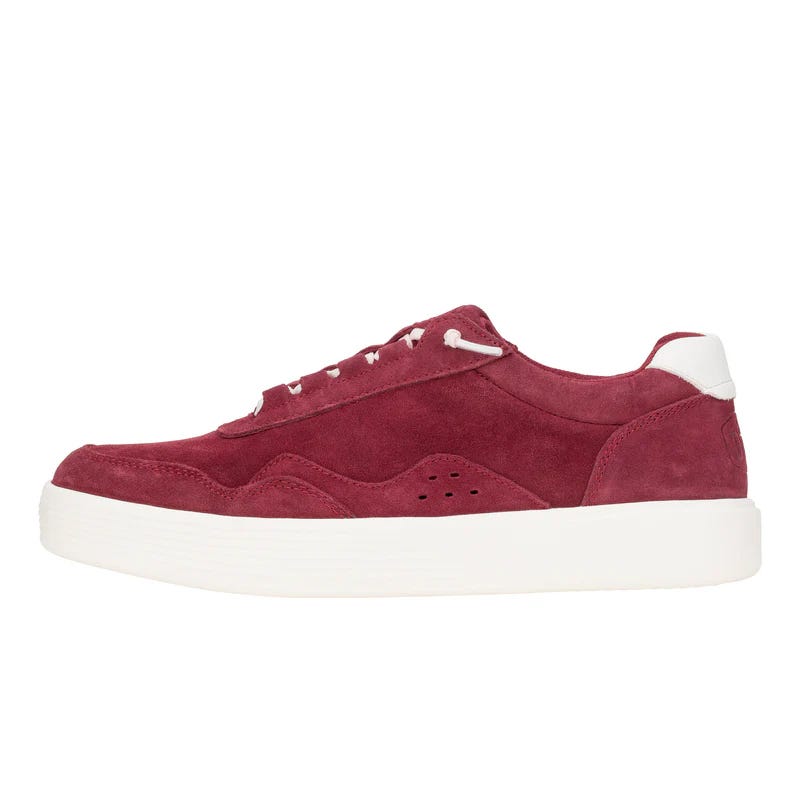 A red suede sneaker with white laces and a thick white rubber sole.