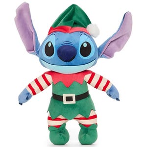 A plush toy of Stitch from Lilo & Stitch dressed as a holiday elf, featuring a green elf outfit with a red and white striped shirt, a black belt, and a green hat with a white pom-pom.