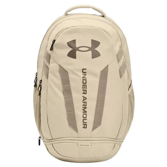 A tan Under Armour backpack with a large logo and vertical branding on the front, featuring multiple compartments and zipper closures.