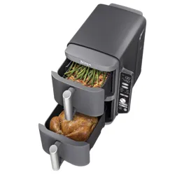 Dual-drawer air fryer with digital controls, cooking roasted chicken in one drawer and vegetables like green beans in the other.
