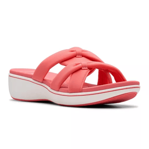 Clarks Breeze Rae Comfort Sandals feature coral-colored padded straps in a crisscross design and a white cushioned sole with a slight wedge for added comfort.