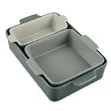 A set of three nested ceramic baking dishes in varying sizes, featuring handles for easy use, with two being gray and one light beige.