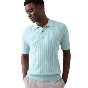 A man is wearing a light blue, short-sleeve, ribbed knit polo shirt paired with light-colored pants.