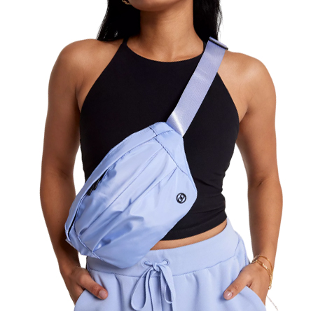 A person is wearing a black sleeveless top and light blue joggers, accessorized with a light blue crossbody bag.