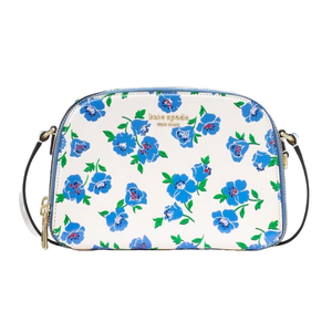 Kate Spade Devin Springtime Blooms Bag features a floral pattern with blue flowers and green leaves on a white background, has a black strap, and gold-tone hardware.