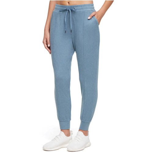 Light blue jogger pants with an elastic waistband, drawstring, and ankle cuffs, worn with white sneakers.