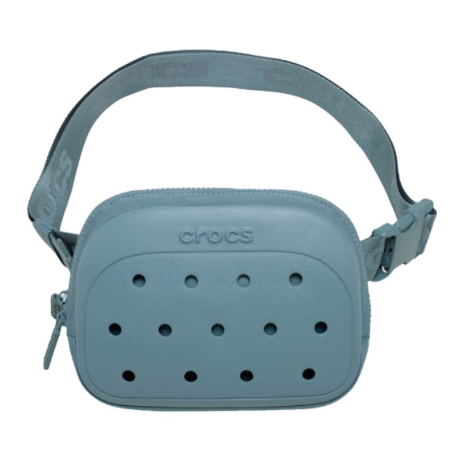 A light blue crossbody bag with a design resembling Crocs shoes, featuring ventilation holes and an adjustable strap with the brand name \“Crocs\“ embossed on it.