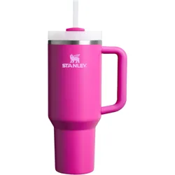 A bright pink Stanley travel mug with a handle and a straw, featuring a stainless steel band near the top and the Stanley logo displayed in white.