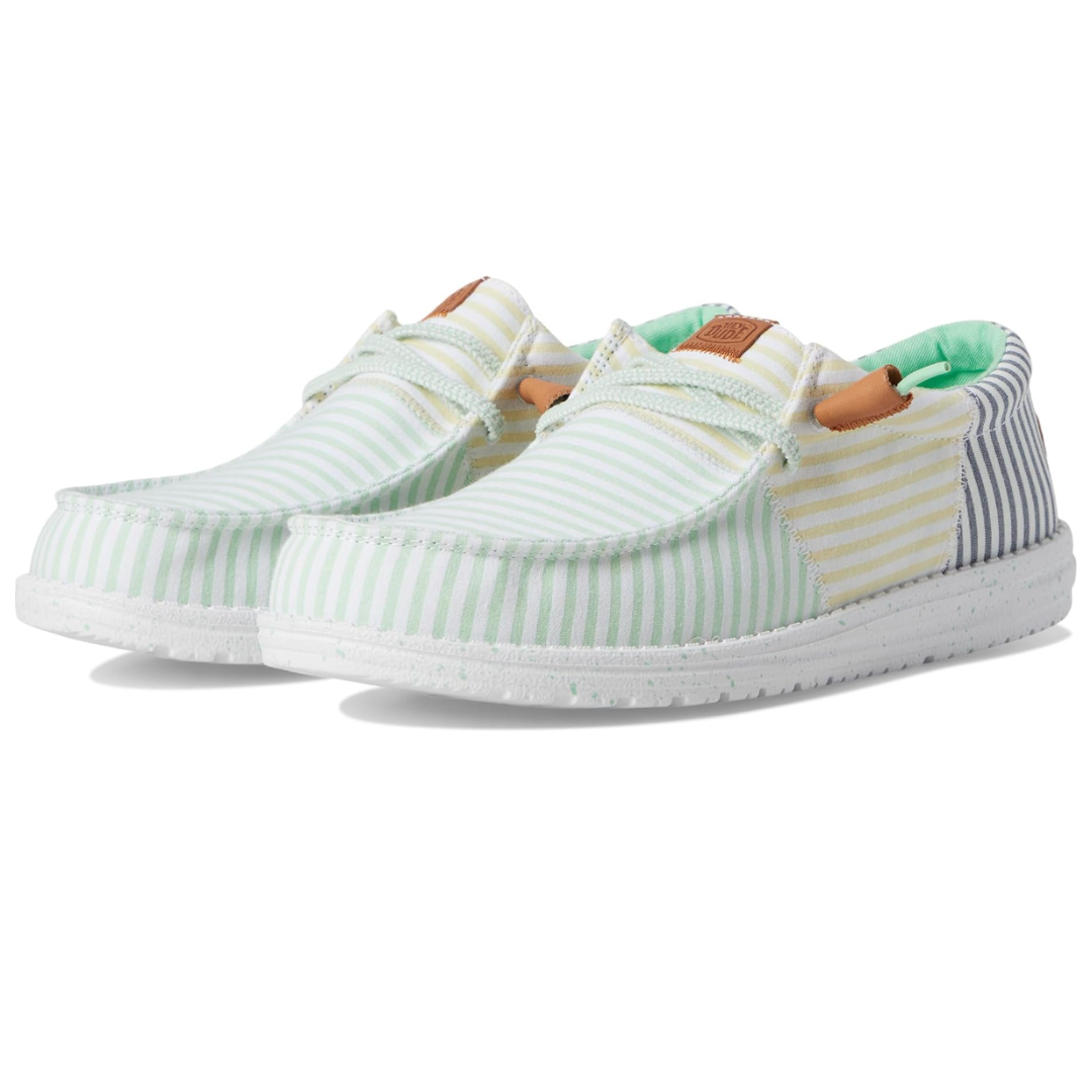 Hey Dude Men's Wally Shoes have a casual design featuring pastel stripes in green, yellow, and blue with a white speckled sole. They include lightweight fabric, moc toe stitching, and a slip-on style with adjustable laces.
