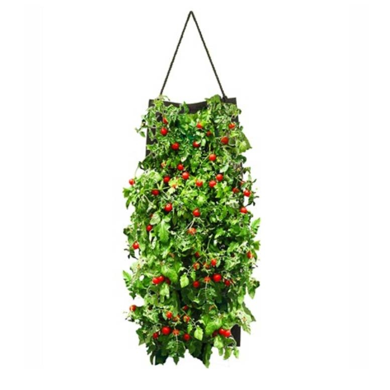A hanging planter bag filled with lush green foliage and vibrant red cherry tomatoes. The bag is suspended by a rope, designed for efficient vertical gardening.
